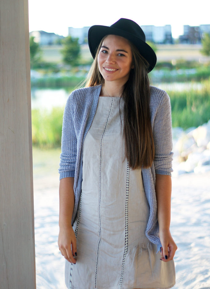 Lauryn Hock wearing an all-thrifted outfit (grey dress, blue cardigan, and hat)