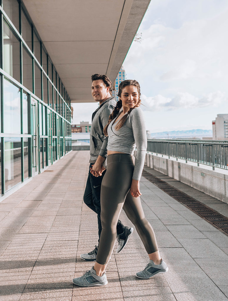 Lauryn and Spencer Hock hold hands while wearing fitness clothing in downtown SLC, UT