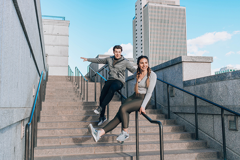 A married couple slides down a stair railing in downtown Salt Lake City, Utah | Lauryncakes shares workout tips