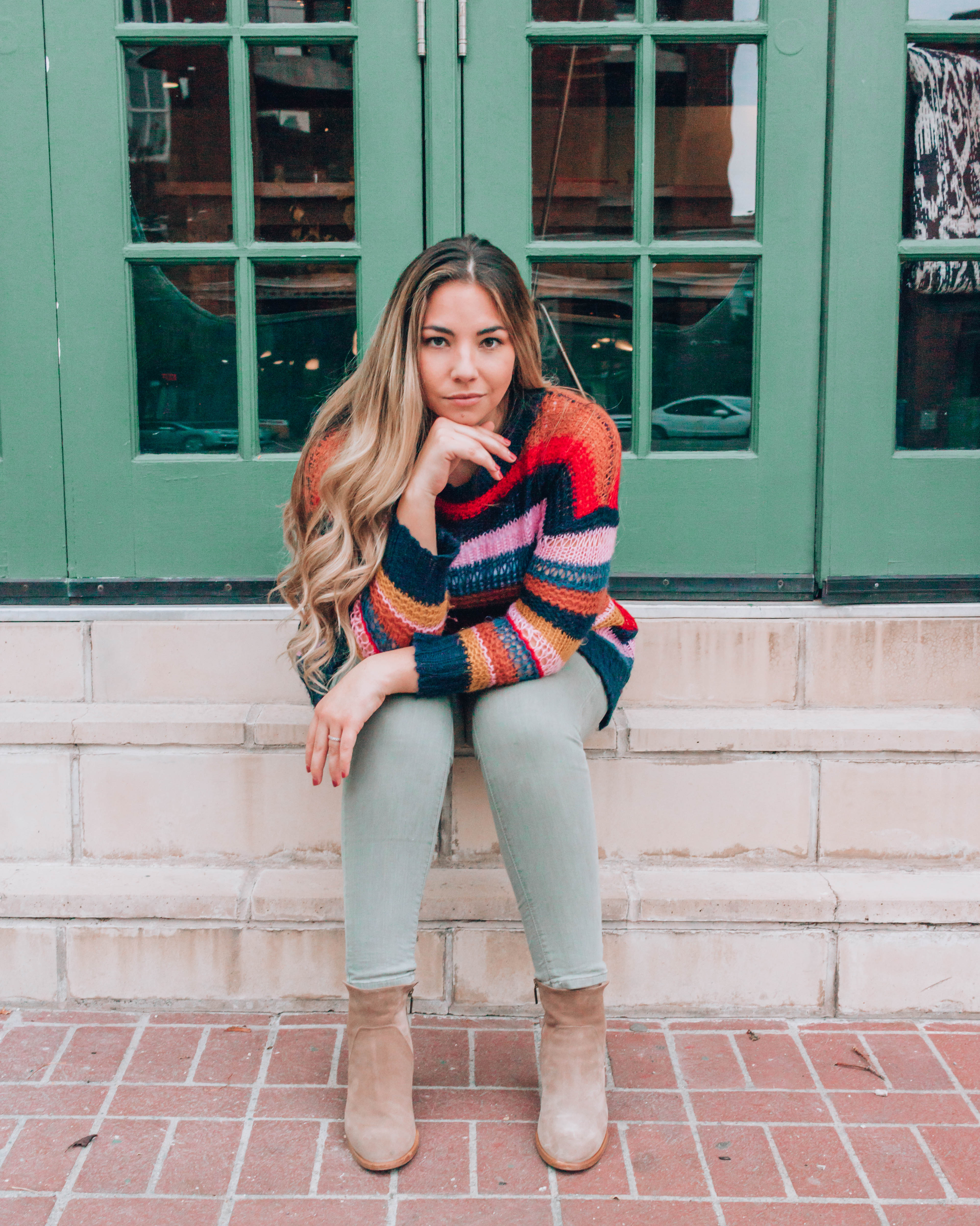 Girl with long blonde hair sitting on steps outside