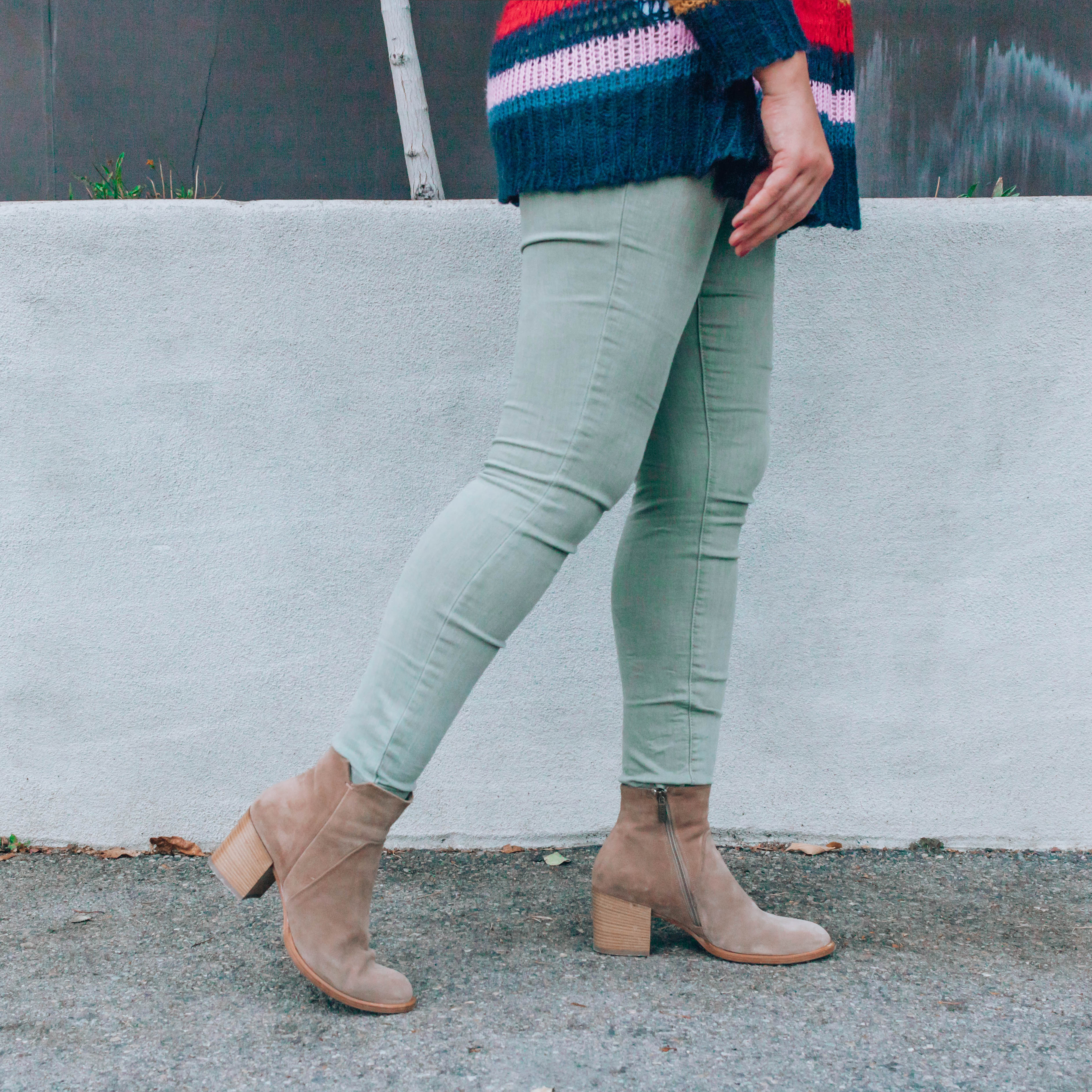 Woman's legs wearing green cotton skinny jeans and tan ankle boots