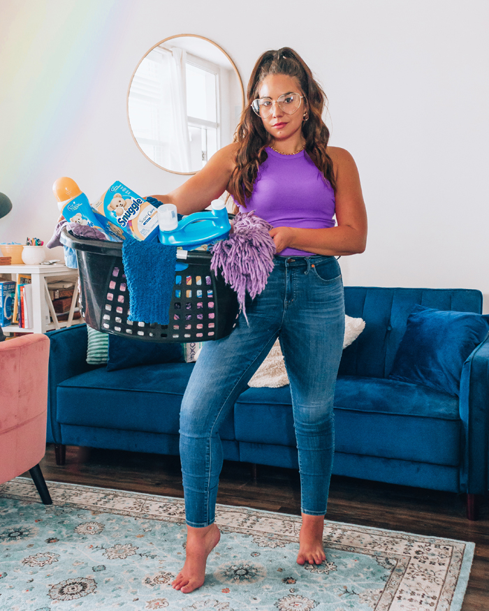 LAuryncakes holds a basket of clothing in her living room | best places to sell your used clothing