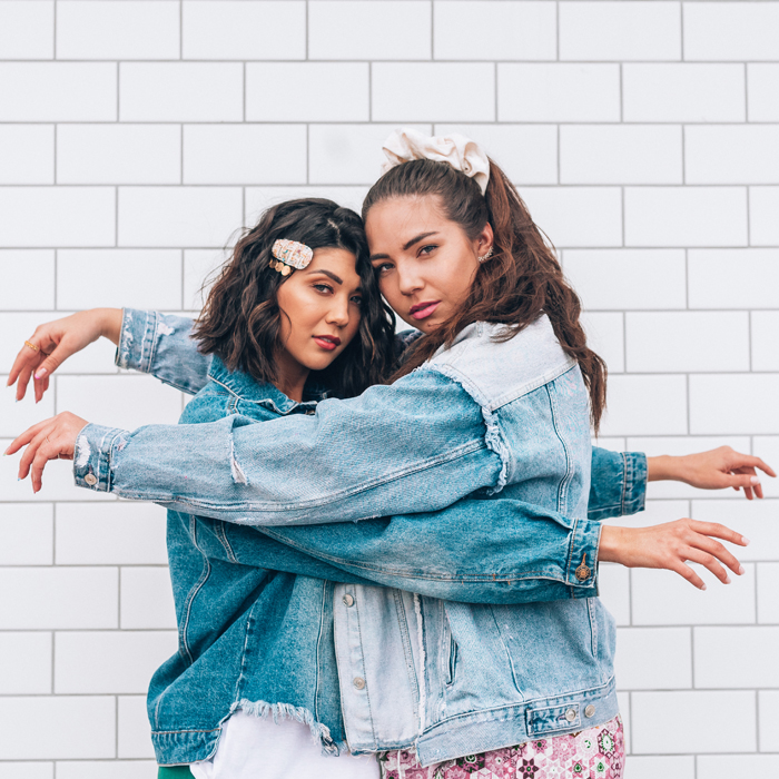 Lauryn Hock and Sabrina Wright embrace in a hug. Both are wearing denim jackets | best places to sell your used clothing
