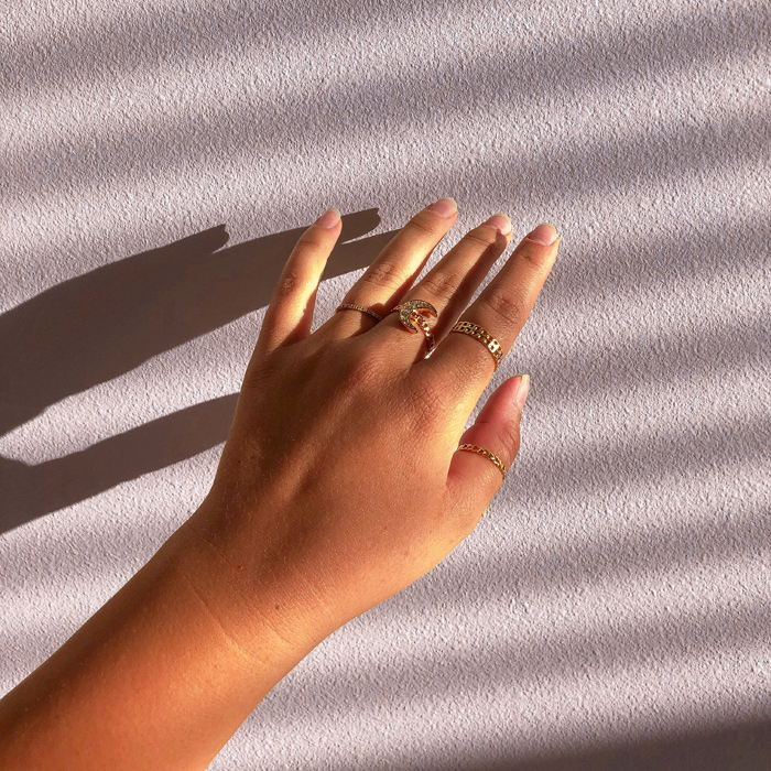 woman's hand being held up against a wall with shadows coming in through window blinds