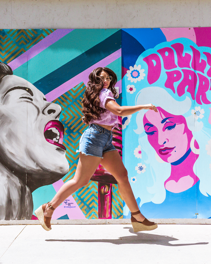 Lauryncakes, blogger from Salt Lake City, Utah, leaps in front of a a mural at The Gateway featuring famous women leaders