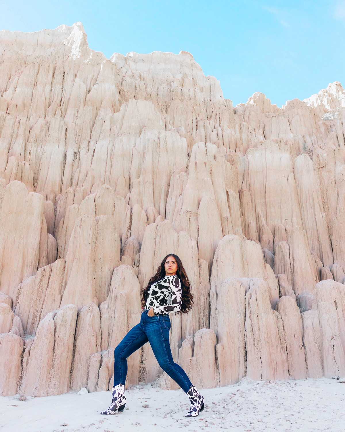 Woman (blogger Lauryn Hock) walking in front of Cathedral Gorge wearing cow print and jeans