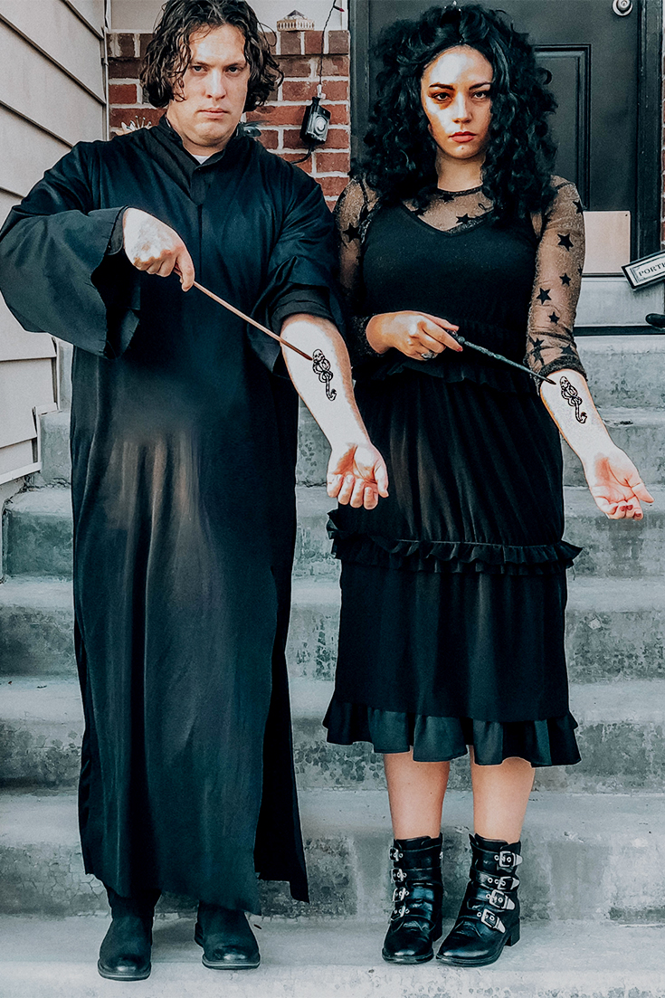 man and women hold their arms out pointing to the dark mark. they are dressed as severus snape and bellatrix lestrange for halloween costumes