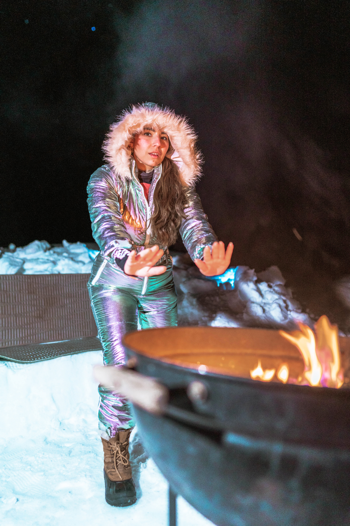 Lauryn Hock warms her hands over a fire during a night snowshoing adventure in Central Oregon
