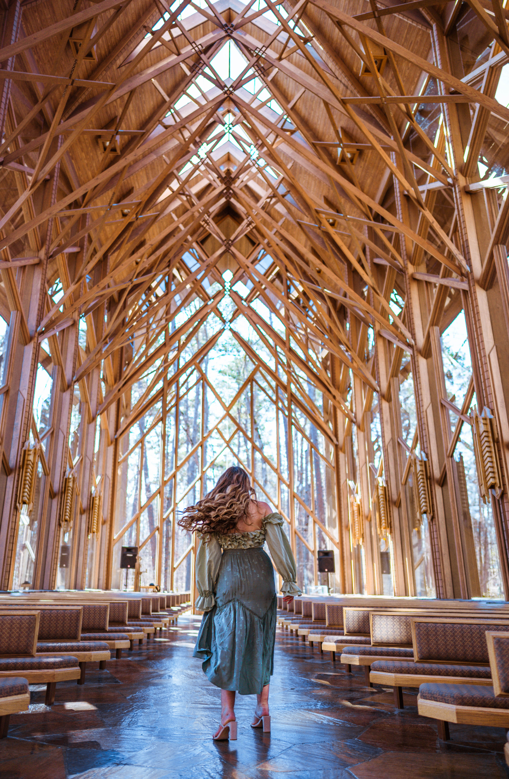 Anthony Chapel at Garvan Gardens with a woman sinning in a skirt near the pews |10 Hot Springs Arkansas Locations You Need To Visit