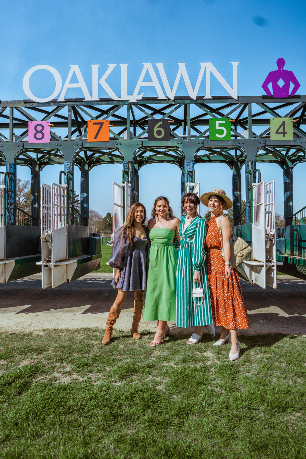 Living Lesh, Lauryncakes, Greta Hollar, and Miss Moore Style standing in front fot he racing gate at the horse races of Oaklawn Casino and Resort | 10 Hot Springs Arkansas Locations You Need To Visit